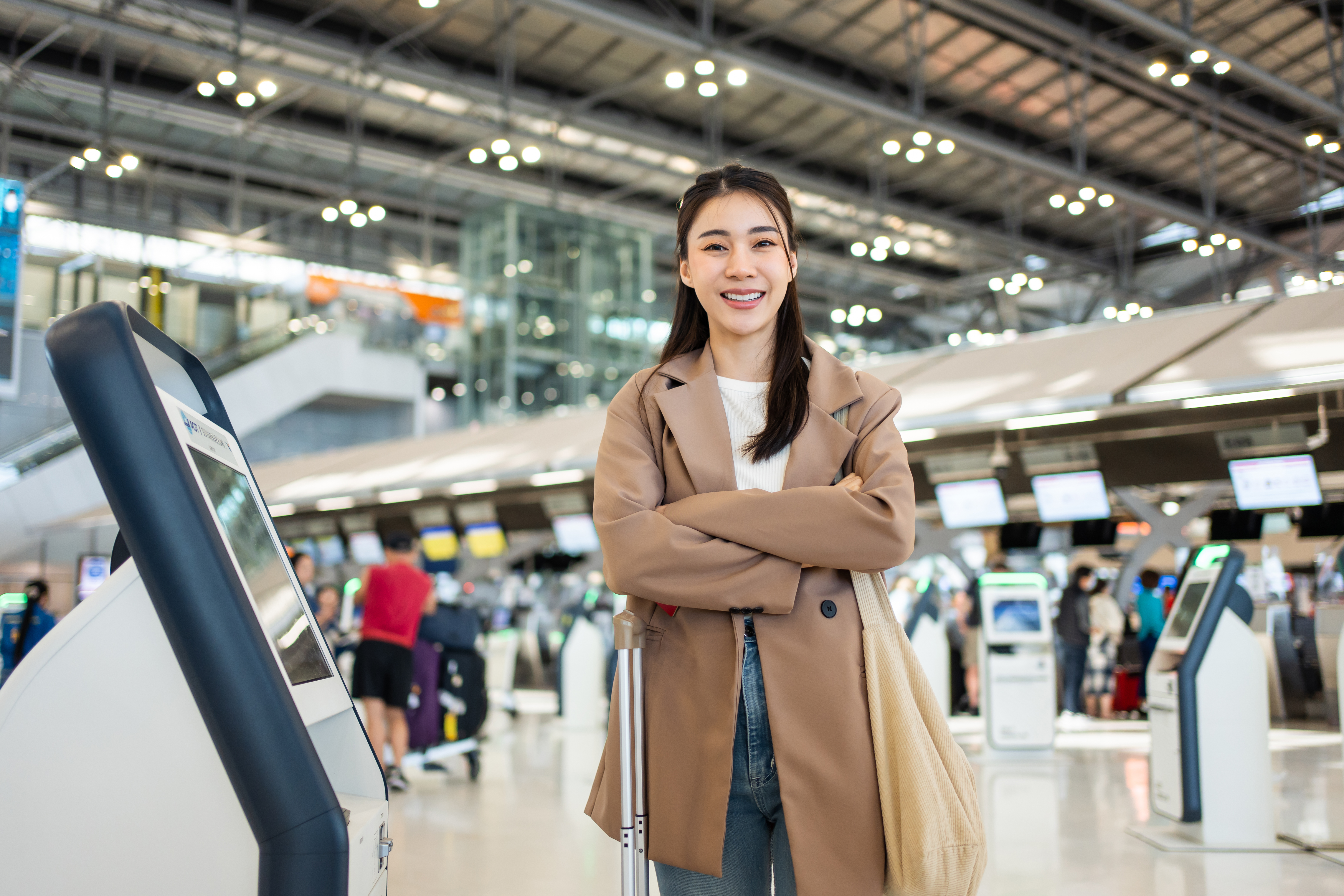 Portrait of Asian young girl walk in airport terminal to boarding gate. Attractive beautiful female tourist passenger feel happy and excited to go travel abroad by airplane for holiday vacation trip.